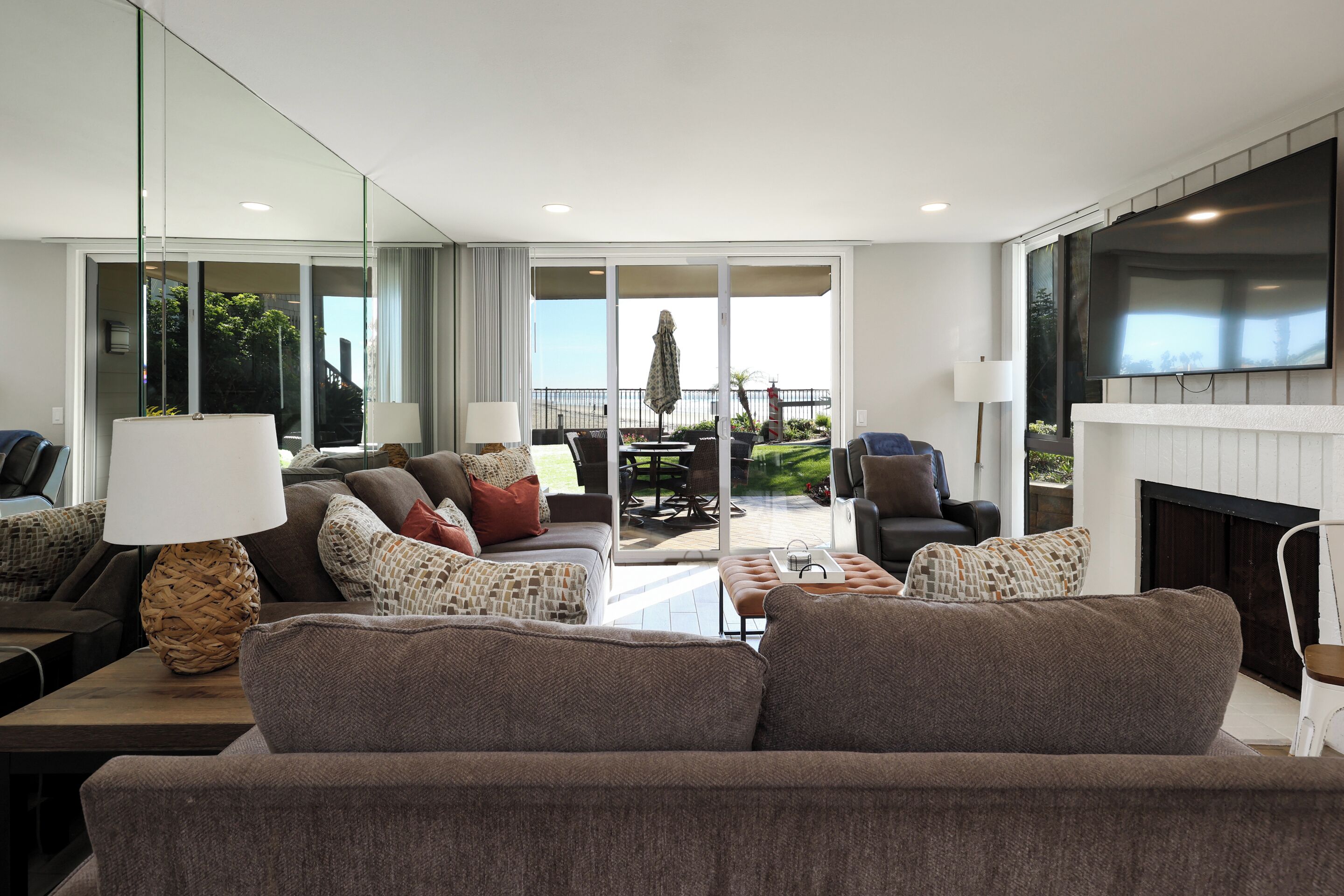 A modern living room with a sofa, armchairs, a coffee table, and a fireplace.