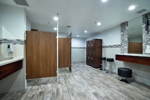Une salle de bain moderne avec des cloisons en bois, un sol carrelé et un grand miroir.