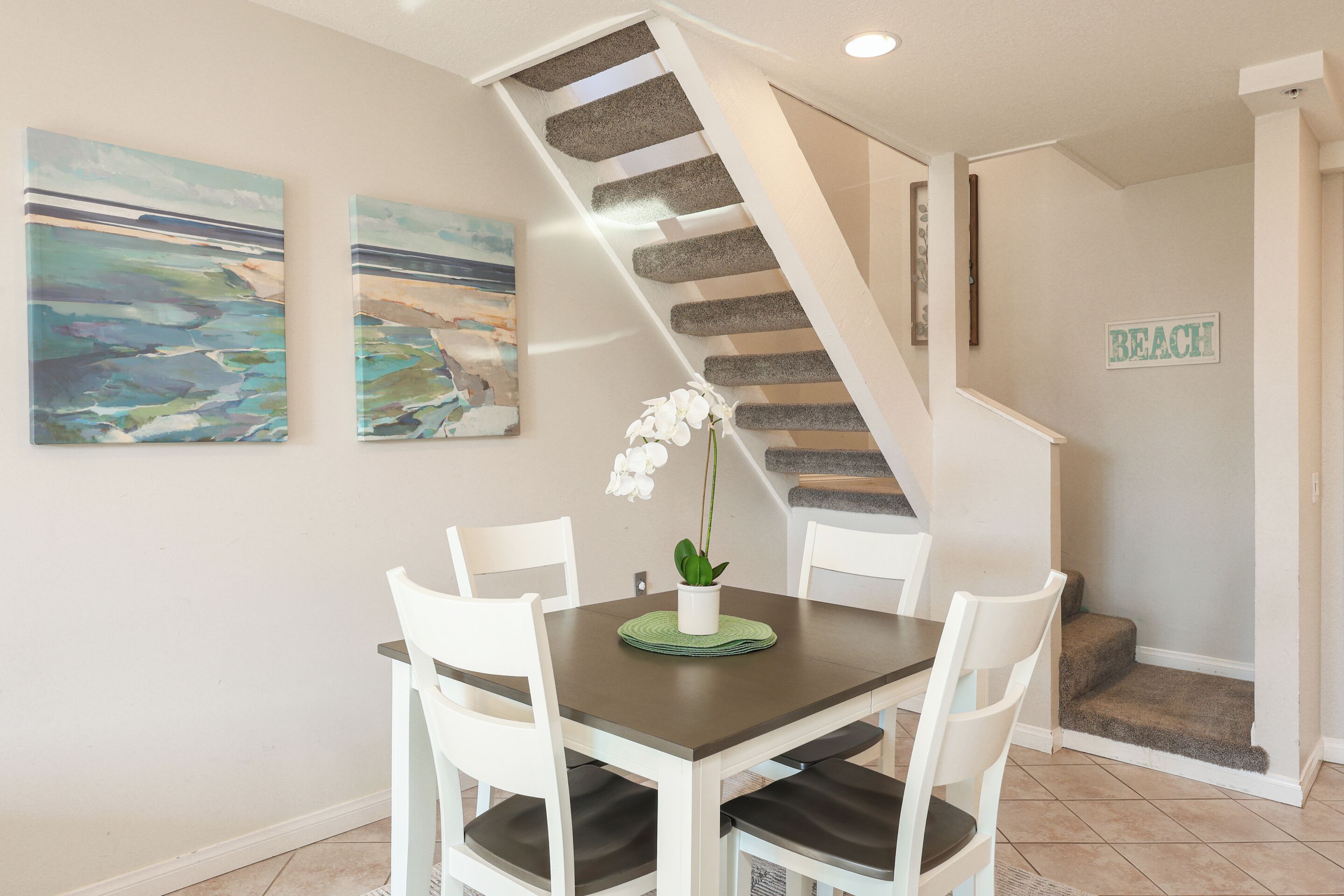 Un comedor con una mesa, sillas y una escalera.