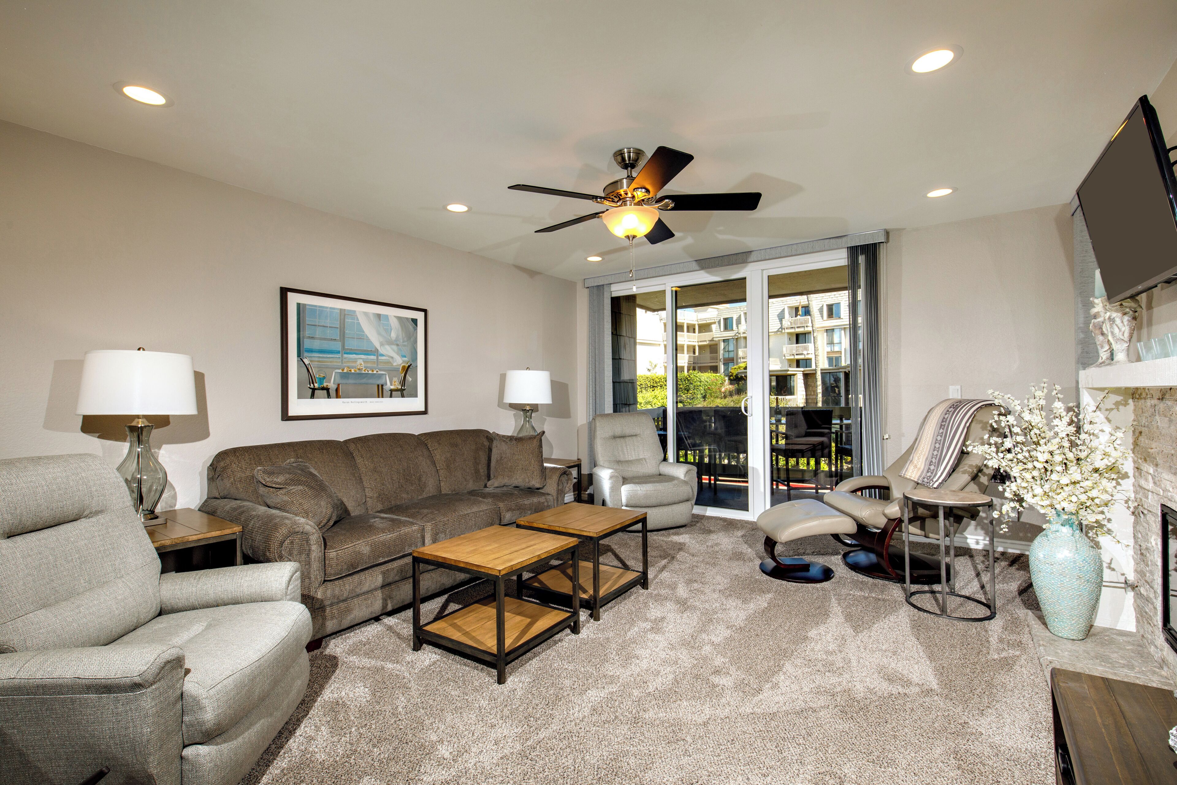 A living room with a sofa, armchairs, a coffee table, and a TV.