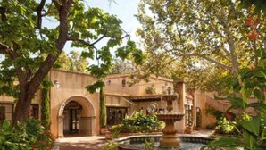 A courtyard with a fountain, brick pathway, and a building with an arched entrance. - Sedona Solace: Your Oasis of Serenity! Great Value. (Sedona)