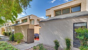A modern building with a beige exterior, multiple windows, and a well-maintained garden area with small plants and a pathway. - Tranquil & bright loft-style townhouse near Sabino Canyon!   (Tucson)
