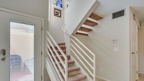 A spiral staircase with white railings and beige carpeted steps leading to an upper floor. - Tranquil & bright loft-style townhouse near Sabino Canyon!   (Tucson)
