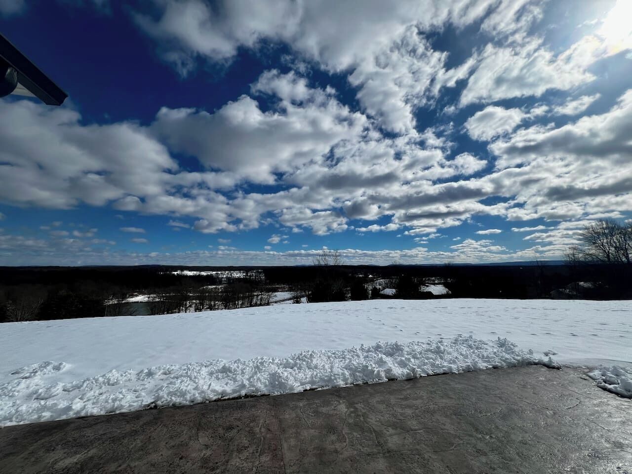Un paisaje nevado con cielo despejado y un sendero de hormigón.