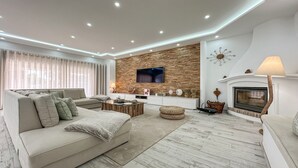 A modern living room with a sofa, coffee table, and fireplace. - ★Luxury Villa Heated Pool, walk to São Rafael Beach, Albufeira (Albufeira)