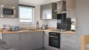 A modern kitchen with a built-in microwave, oven, and sink. - Patrington Haven is a pristine lodge park with an array of facilities. (Patrington, near Hull)