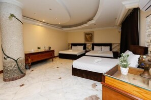 Une chambre d’hôtel avec une grande colonne, un lit, une table de chevet, une commode et un tableau au mur.