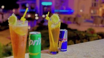 Three beverages on a ledge with a building in the background.