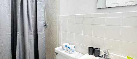 A bathroom with a toilet, sink, and shower curtain.