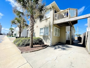 A two-story house with a balcony, a driveway, and a parking unit sign.