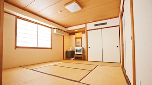 A traditional Japanese room with tatami flooring, a television, and sliding doors. - HOTEL THE NEXT KANKU (Sennan)