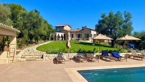 A poolside area with lounge chairs, a stone building with a tiled roof, and a well-maintained lawn. - Valbonne Villa with fantastic view and large swimming pool (Valbonne)