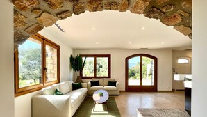 A spacious living room with a stone archway, large windows, and a view of the outdoors. - Valbonne Villa with fantastic view and large swimming pool (Valbonne)