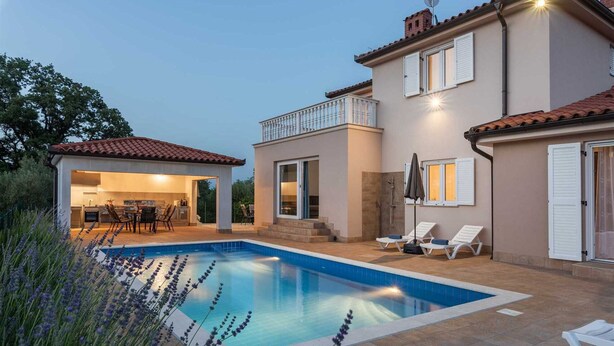 Ein modernes Haus mit Swimmingpool, Sitzgelegenheiten im Freien und einer überdachten Terrasse.