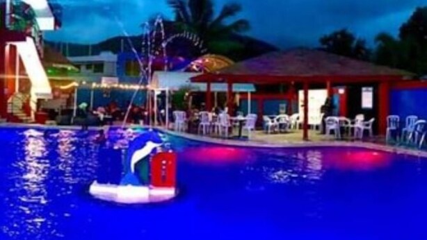 A swimming pool with a water slide, lounge chairs, and a covered seating area. - Dilias house RANCH (Sabana Larga)
