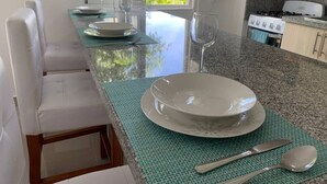 A kitchen with a dining area, a stove, and a window with a view of greenery. - Conchita de Mar (Punta Cana)