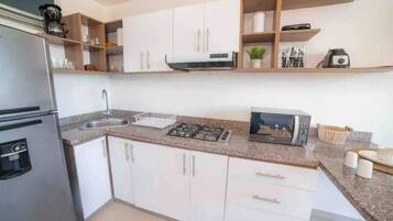 Fridge, microwave, coffee/tea maker, cookware/dishes/utensils