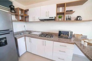 Fridge, microwave, coffee/tea maker, cookware/dishes/utensils
