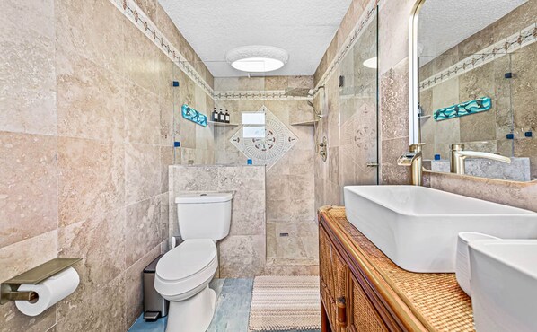 Une salle de bain avec des toilettes, un lavabo et une douche.
