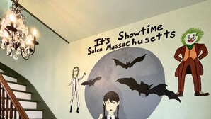 En trappe med et vægmaleri i Halloween-tema, der viser flagermus og en figur, der ligner Jokeren.