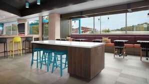 A modern restaurant with a central island, bar stools, and a seating area with a view. - Tru By Hilton Jackson, Tn (Jackson)