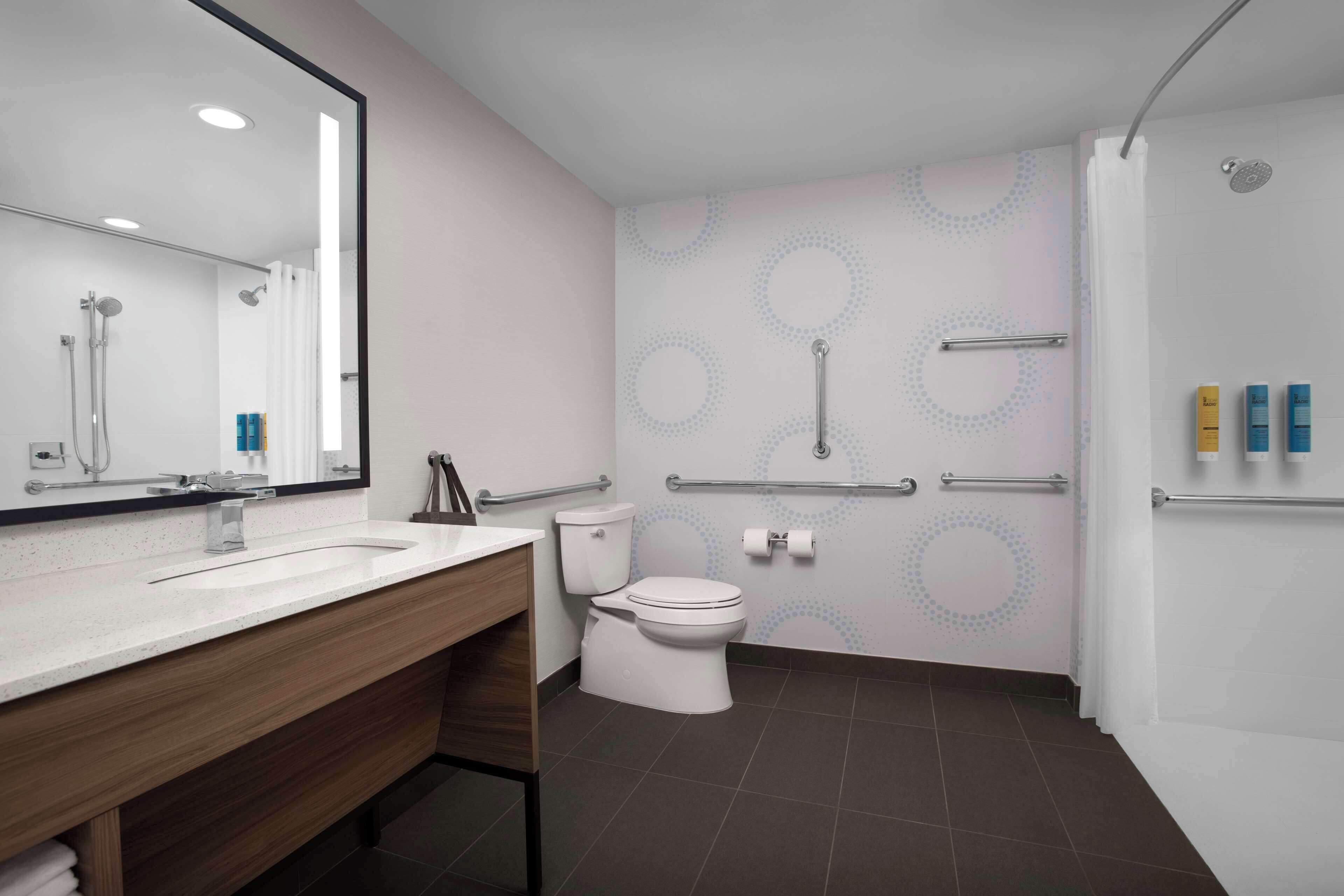 A modern bathroom with a sink, toilet, and shower.