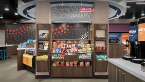 A snack kiosk with a variety of packaged foods and beverages, a 24/7 market sign, and a Hilton logo indicating nearby hotel services. - Tru By Hilton Jackson, Tn (Jackson)