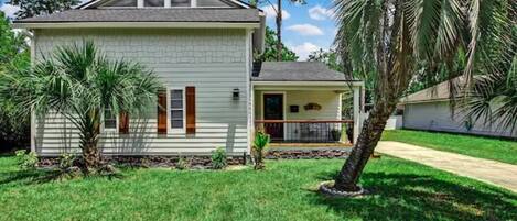 A single-story house with a front porch, a small attached garage, and a well-maintained lawn.