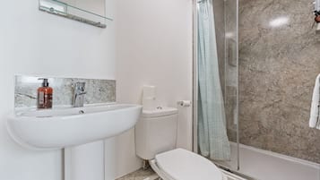 A bathroom with a white sink, a toilet, and a shower with a glass door.