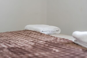 A neatly arranged set of towels on a bed with a textured brown cover.
