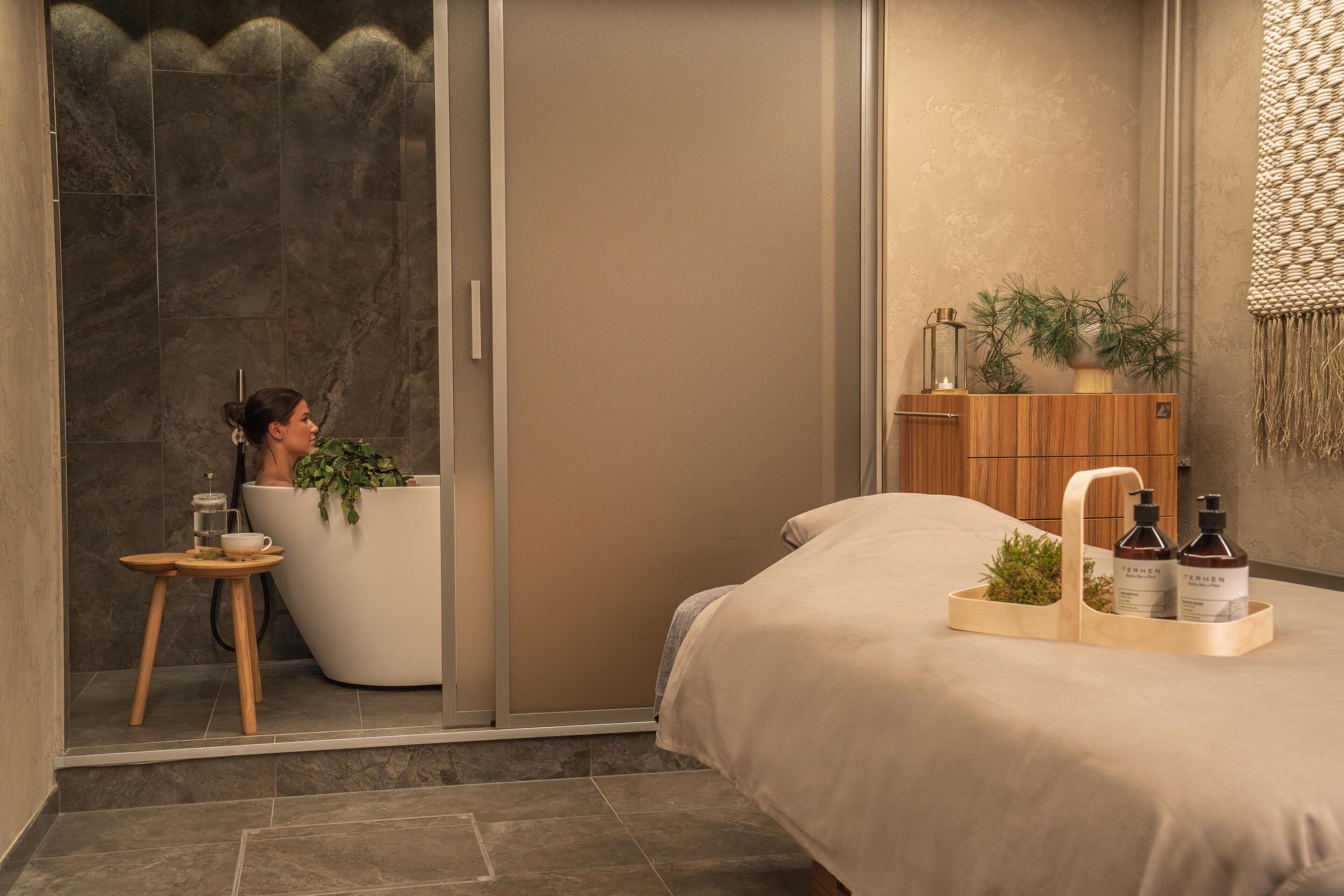 Un baño moderno con una bañera, un taburete de madera y una mesita.