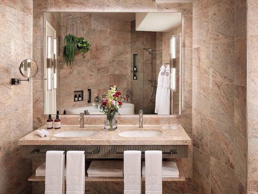 Un baño moderno con dos lavamanos, un espejo grande y una ducha.