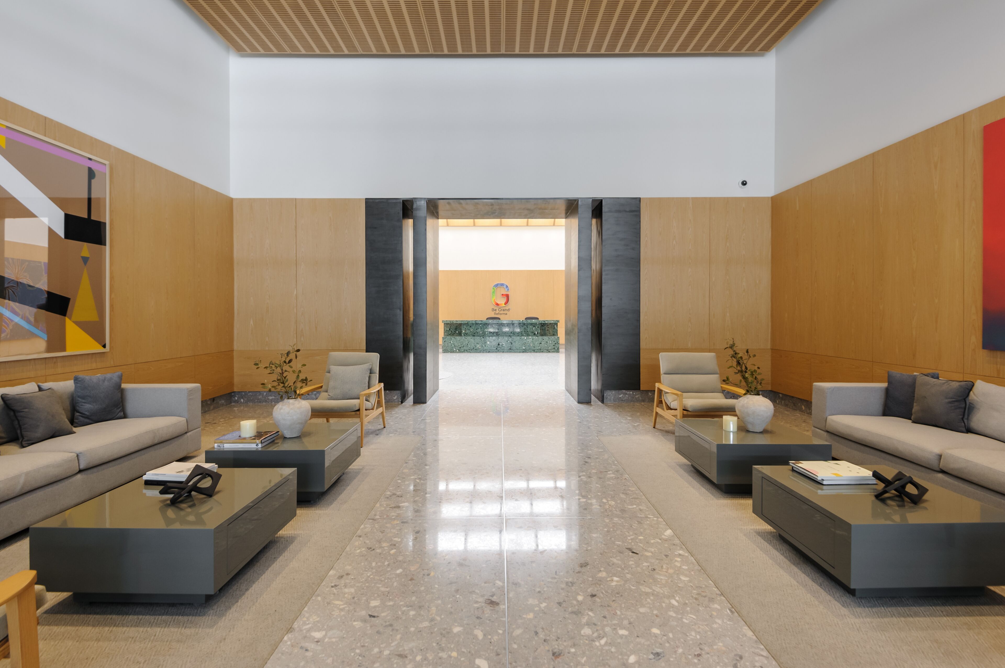 A modern lobby with a reception desk, two sofas, and a coffee table.