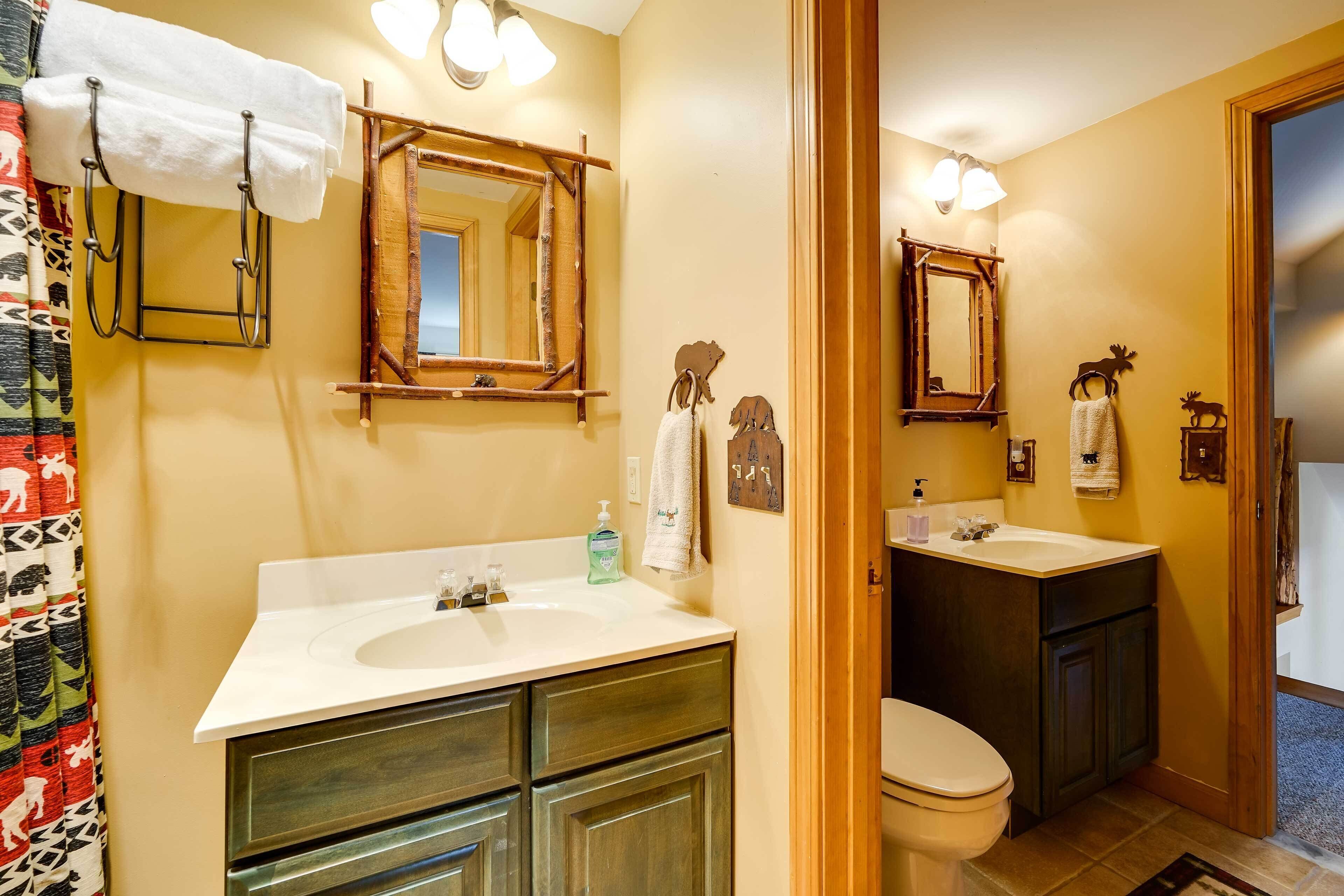 A bathroom with two sinks, a toilet, and a shower curtain.