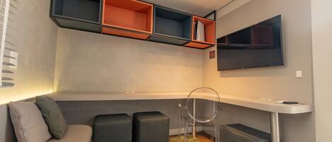Ein modernes Wohnzimmer mit einer Couch, Poufs, einem Sessel und eingebauten Regalen.