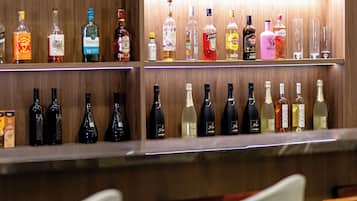 A bar area with shelves of various liquor bottles and glasses.