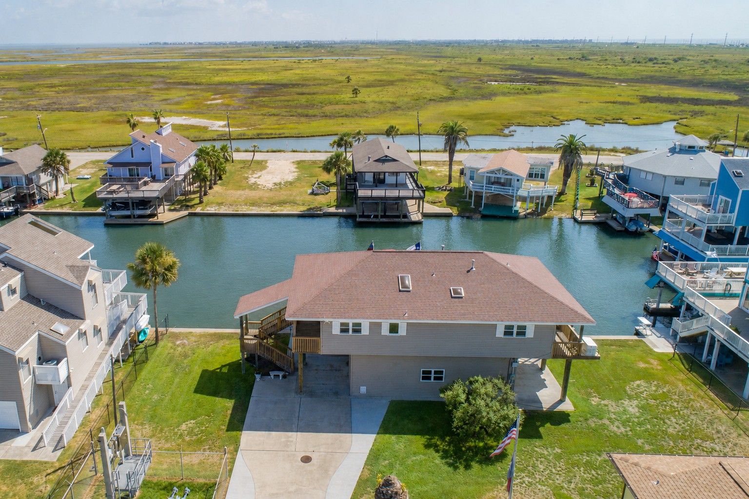A residential area with houses adjacent to a waterway, featuring a dock and a boat.