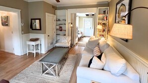 A spacious living room with a white sofa, a coffee table, and a bookshelf.