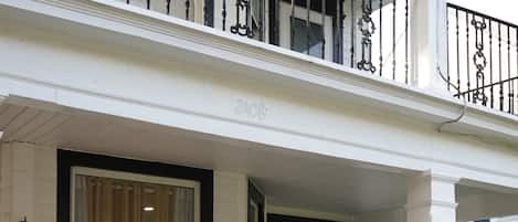 A two-story house with a porch, a white door, and a black mailbox.