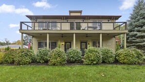 A two-story building with a balcony on the upper floor, surrounded by well-maintained bushes and a grassy lawn. - Condo in the Heart of Douglas - Chef's Kitchen (Douglas)