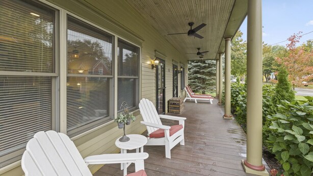 A covered porch with white Adirondack chairs, a small table, and a ceiling fan. - Condo in the Heart of Douglas - Chef's Kitchen (Douglas)