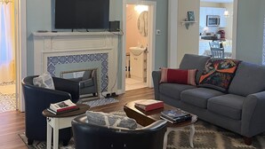 A living room with a fireplace, a television, and a sofa.