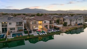 Un barrio residencial con casas modernas, una piscina y vistas a montañas al fondo.