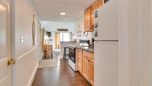 A kitchen with wooden cabinets, a stove, and a refrigerator. - Lake George Waterfront Cabin w/ On-Site Marina! (Bolton Landing)