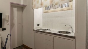 A kitchen with a sink, window, and door.
