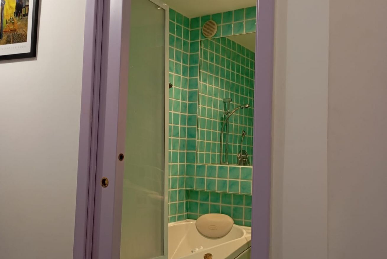Et badeværelse med bruser, badekar og toilet.