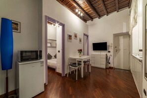 A compact living space with a kitchenette, a dining area, and a TV mounted on the wall. - GuestHost - Apartment located on the ground floor of a renovated period building. There are 5 steps to reach the floor and 1 step at the entrance.It comfortably accommodates two people in 40 m2 of space, the apartment is located a few steps from the wond (Roma)
