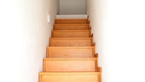 Una escalera de madera que conduce a un rellano con una pared de color claro.