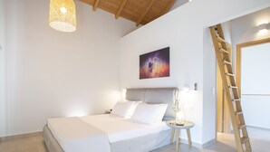 Un dormitorio con cama, mesita de noche, lámpara y una escalera apoyada en la pared.