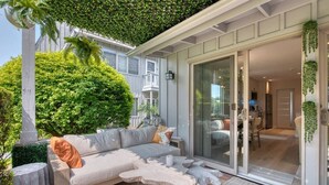 A cozy outdoor seating area with a sofa, cushions, and a unique coffee table.